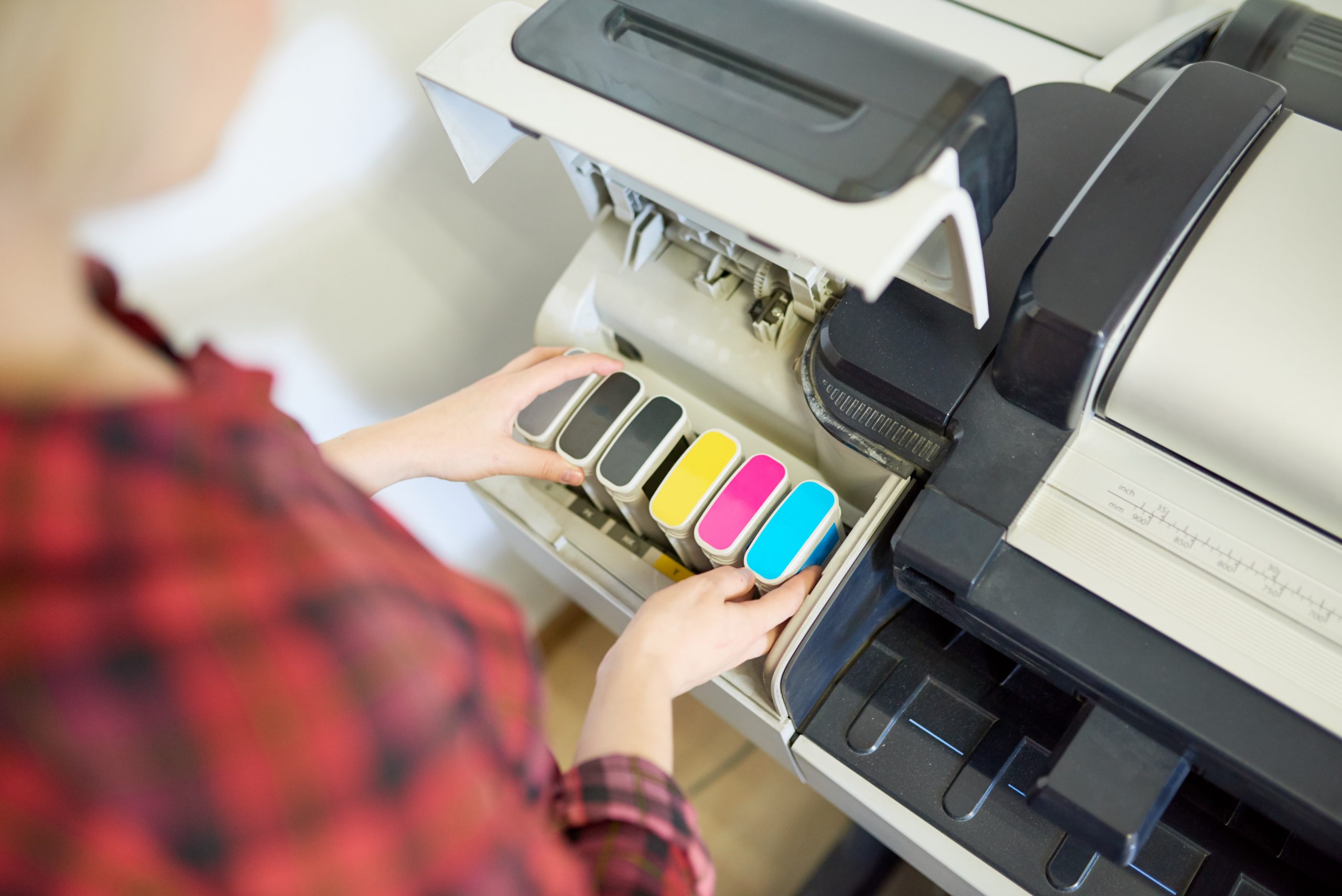 Crop woman putting ink in printer